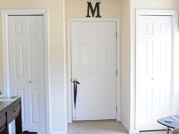 Looking at front door. Two storage closets with hanging rods
