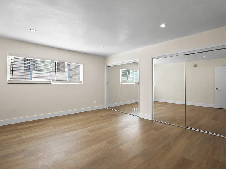 Large Bedroom with Double Mirrored Closets and Vinyl Flooring