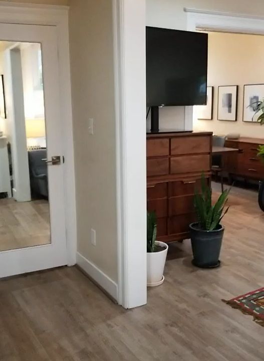 View from foyer into living room and dining room on right. Hall closet, pantry behind mirrored door.