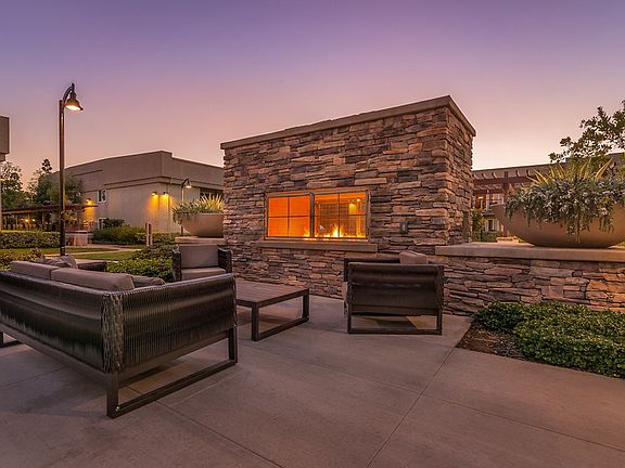 Outdoor fireplace with outdoor sofa and chairs.