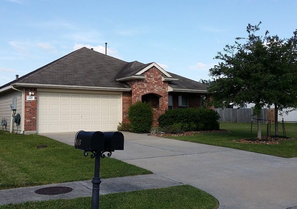 Huge bushes in front of full front porch with bench for rela