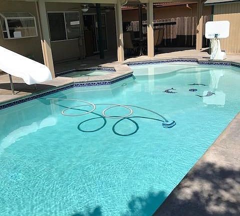 This yard is the perfect spot to enjoy summer!  There's plenty of patio space, a slide for the pool and a balcony overlooking it all.