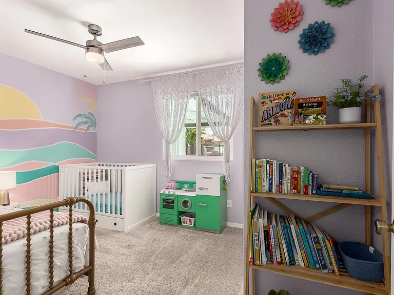 Kid's room with twin bed and crib, books and toys.