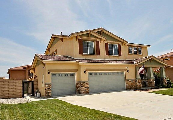 3 car garage and side yard with paved area