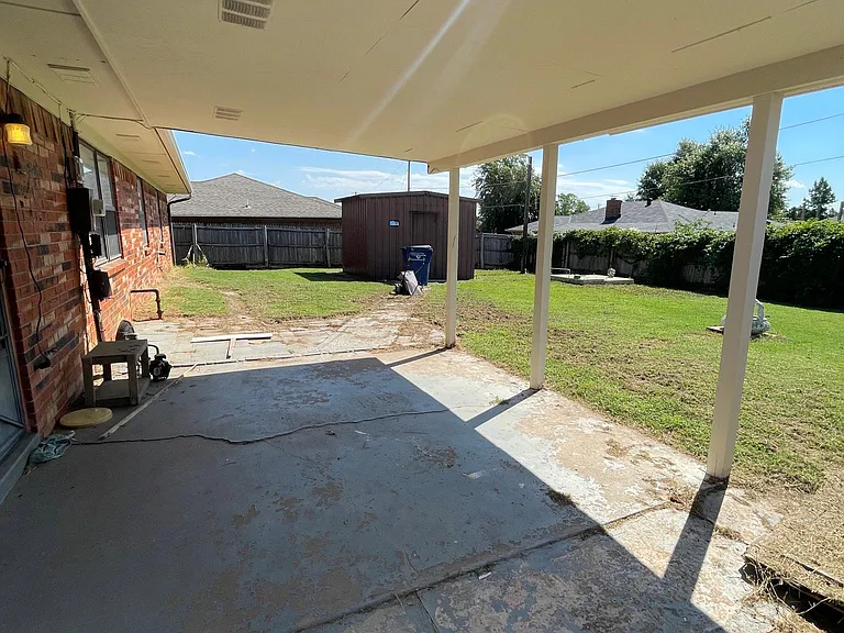 Back patio, large storage building and underground storm shelter