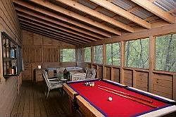 Screened back porch with hot tub, dining table, pool table