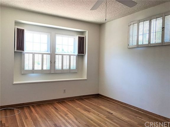 The master suite is at the front of the home and has shutters & a ceiling fan.