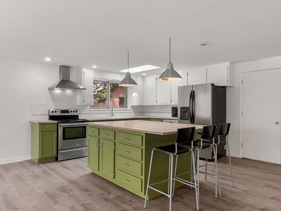 Modern open kitchen with stainless steel appliances and hood, great for entertaining