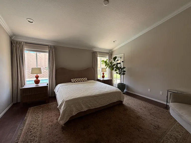 Primary bedroom featuring vaulted ceilings and a relaxing atmosphere.
