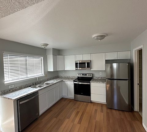 Bright kitchen with brand new cabinets, countertops, sink and apliances.