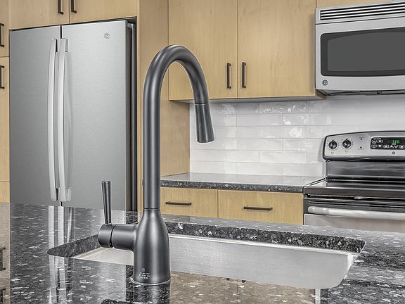 Beautifully renovated kitchens feature modern white subway tile backsplash and sleek matte black fixtures