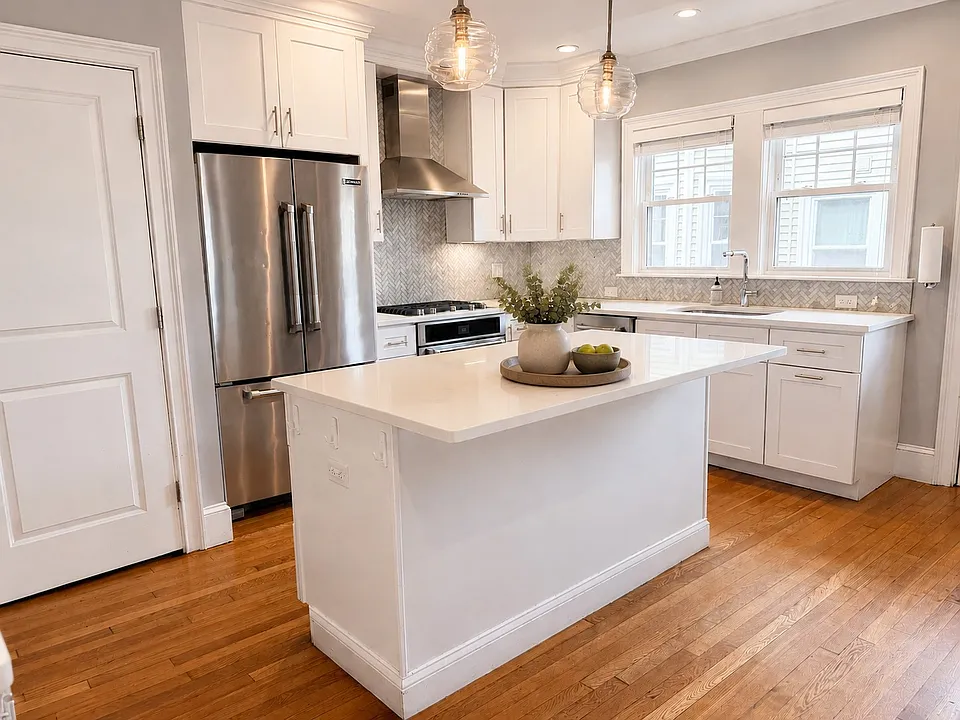 Renovated kitchen with oversized island, quartz countertops, and stainless steel, JennAir appliances