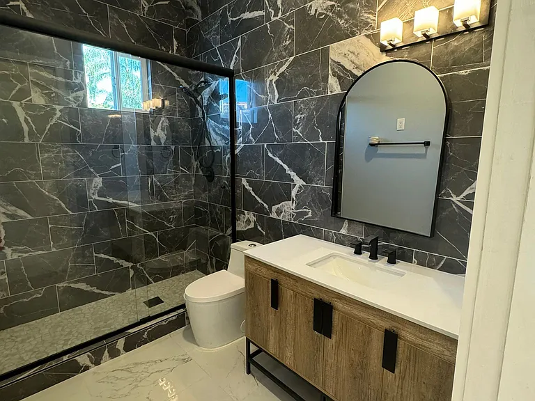 Guest bathroom with high glass, all tile and niche.