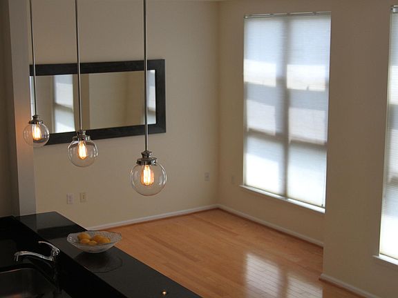 View from the stairs of our light-filled living and dining area open floor plan. Shade control top down and bottom up. High end light fixtures. Mirror in photo is offered for your use.