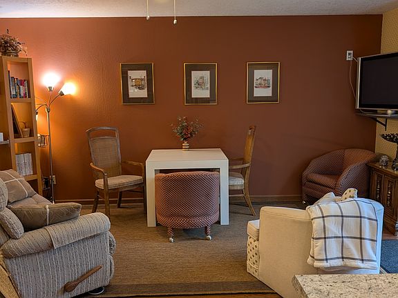 Living area with a reclining couch on each end. Dining table and chairs.