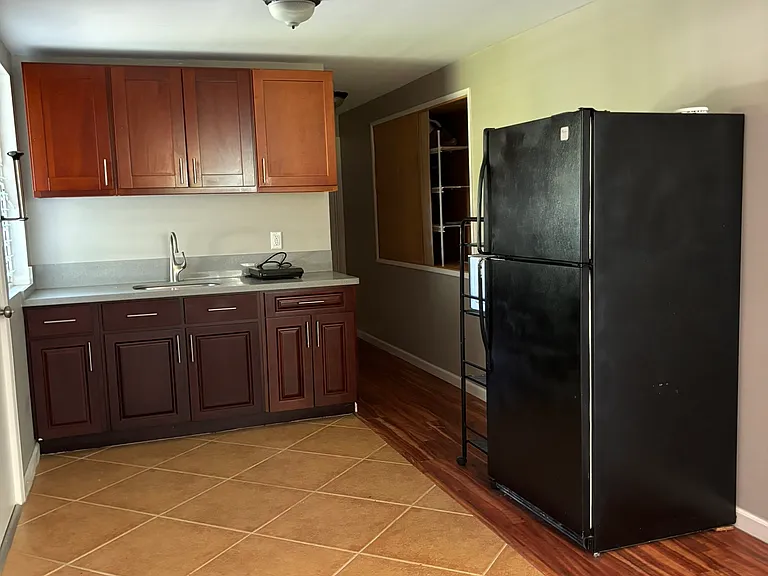 Kitchen includes hot plate, refrigerator, and microwave