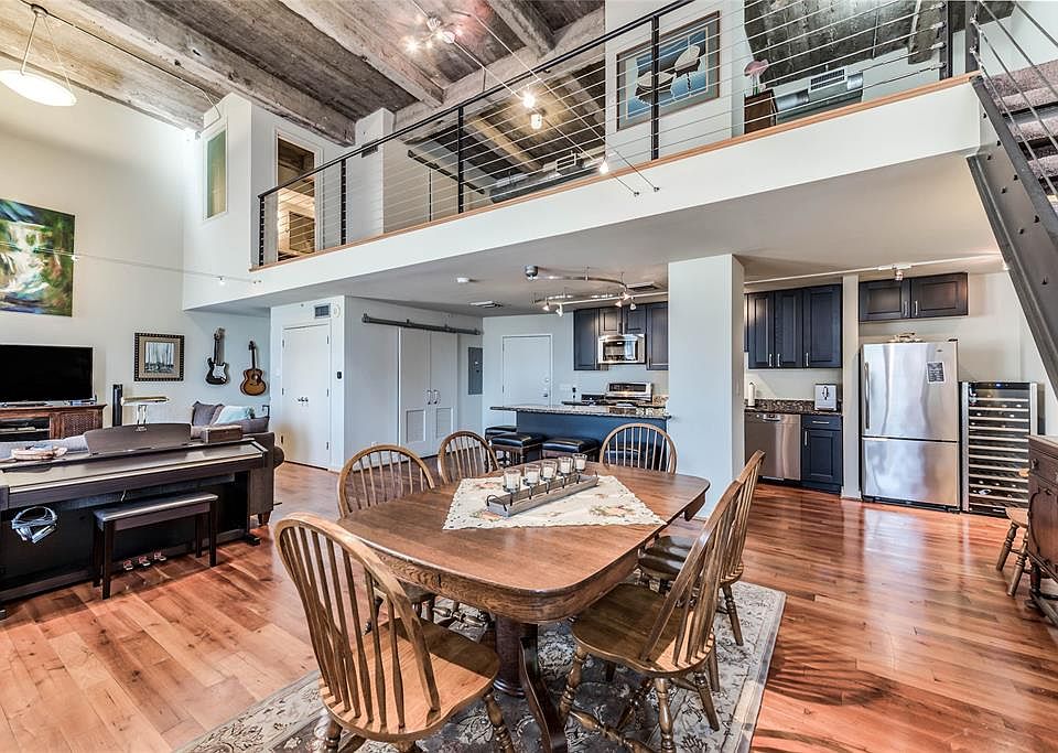 A fantastic view pointing out the dining space, living space to the left, kitchen with ample extra seating in the back, and last but certainly not least, a view of the open stairway leading up to the Primary Bedroom and Bath. The sliding barn doors l