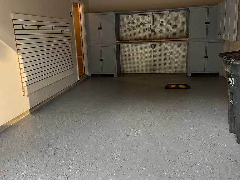 Immaculate garage with additional storage and work bench and storage shelves.