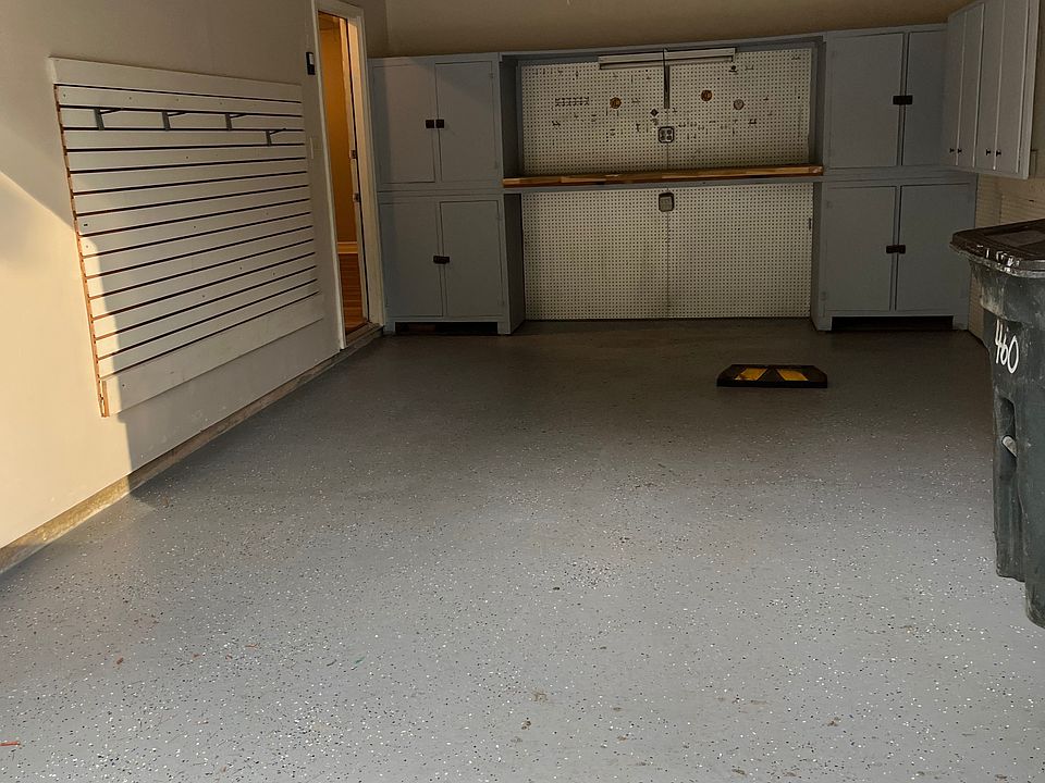 Immaculate garage with additional storage and work bench and storage shelves.