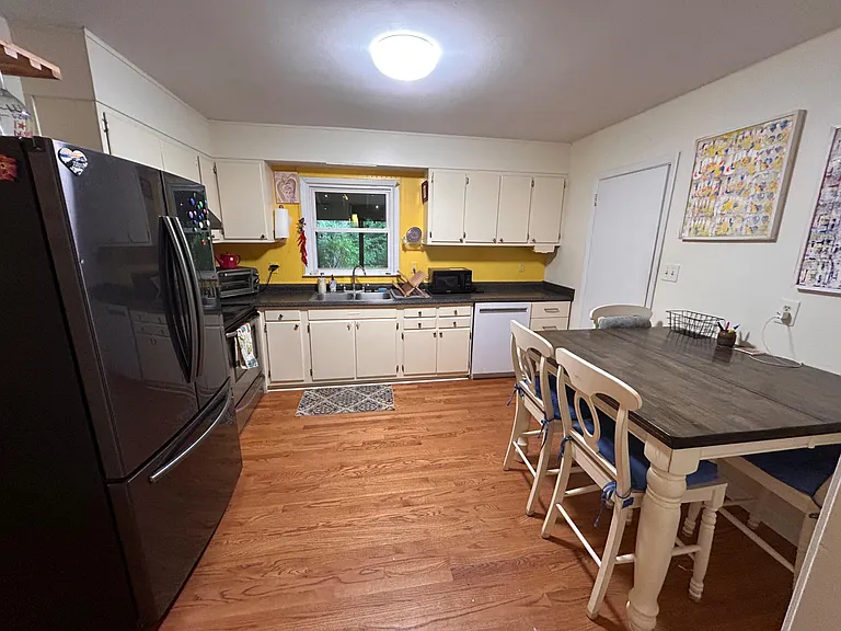 Functional eat-in kitchen with ample cabinet storage, full-size appliances, and a window over the sink for ventilation.