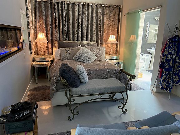 Suite facing North wall. Walk in closet with washer and dryer and full size fridge through a door behind the curtain.