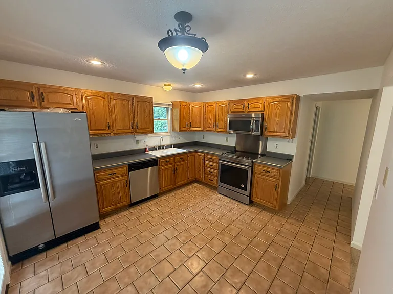Kitchen with brand new stainless steel smooth top range and backsplash