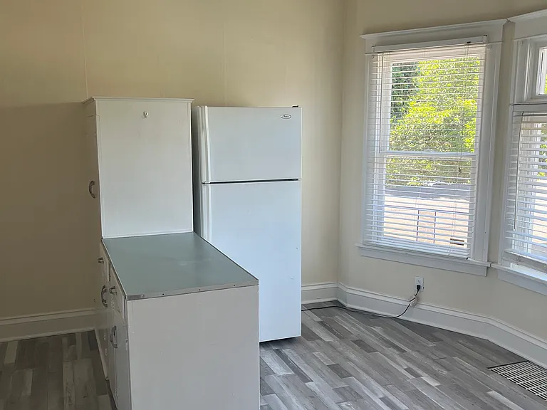 Kitchen large bay windows over looking side yard large ceiling fan full size fridge