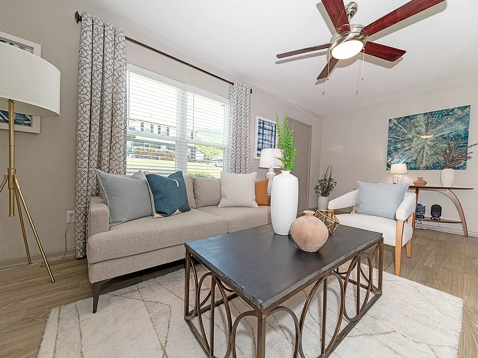 Spacious living room with hardwood-style flooring & ceiling fan
