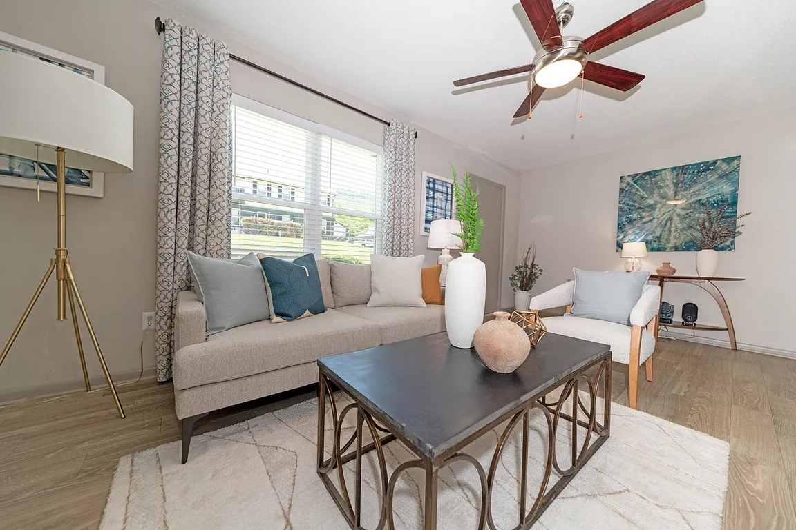 Spacious living room with hardwood-style flooring & ceiling fan