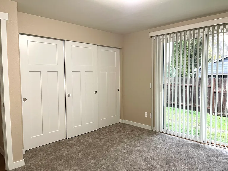 Primary bedroom with a wall of closets and private access to the back yard.