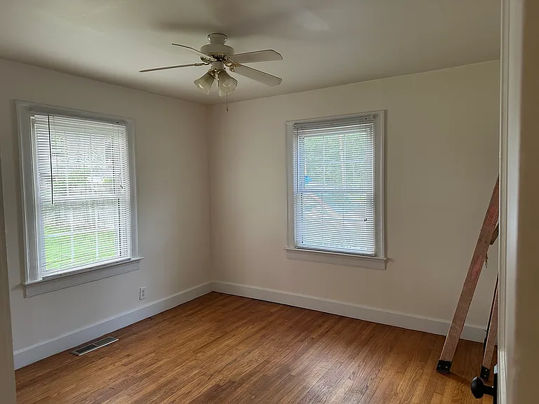 Bedroom 2 with 2 windows for cross-ventilation, ceiling fan and hardwood floor.