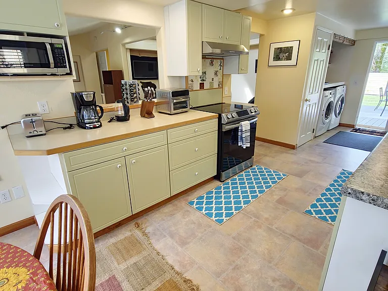 Galley kitchen with new dishwasher, induction range, microwave and numerous accessories.