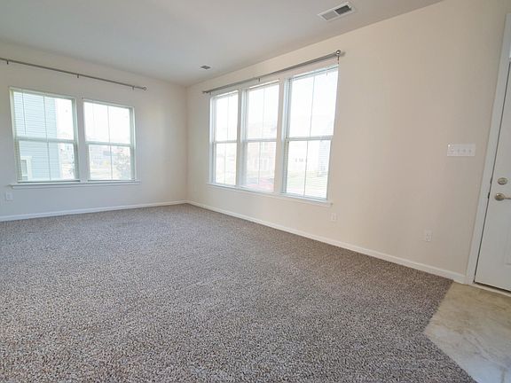 SPACIOUS FAMILY ROOM FEATURES EASY TO DECORATE "TAB TOP" CURTAIN RODS THAT MATCH THE NICKEL FINISHED LIGHTING AND DOOR KNOBS THROUGHOUT THE HOME!