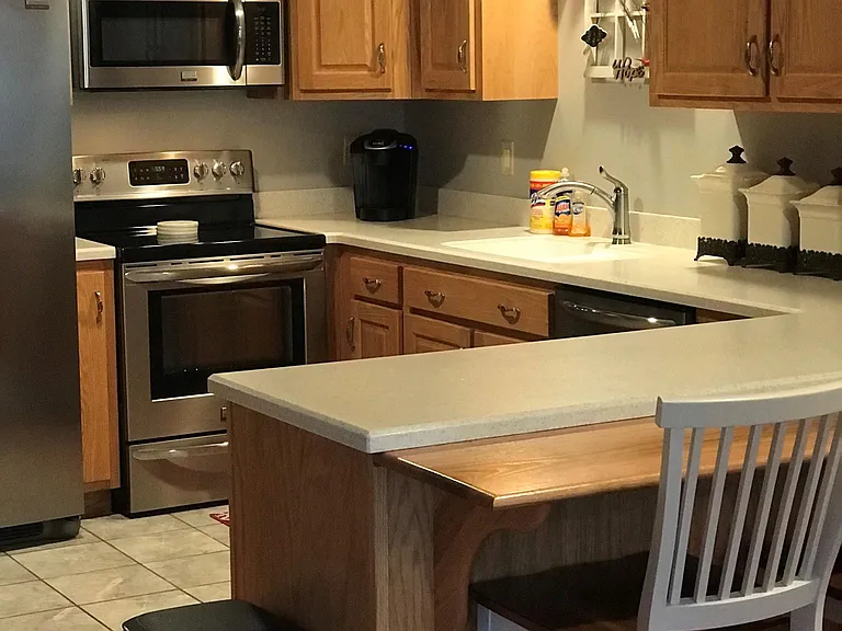 Kitchen stocked with dish towels, cookware, bakeware and utensils.