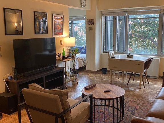 Living area includes a big leather couch, side chair, TV and console, drop-leaf dining table, and coffee table.