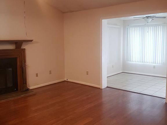 Living room with working fire place, vaulted ceiling, and adjoining sun room.
