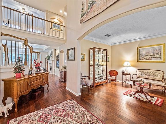 The formal living room features wood flooring and crown moulding. This room can be used as study.