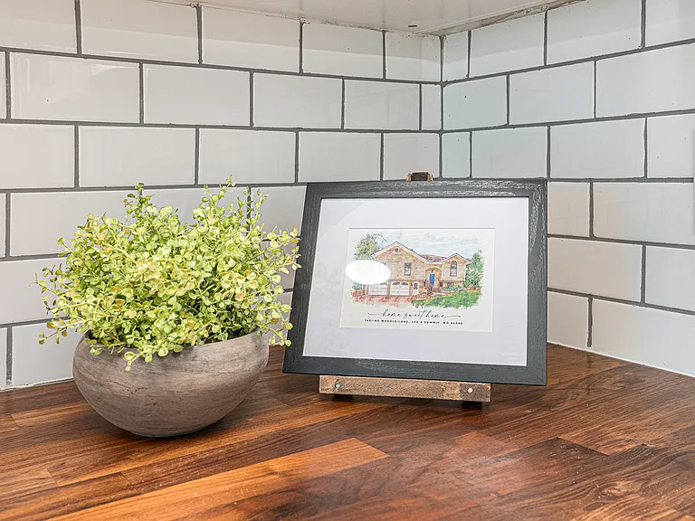 Thoughtful decor with artwork and greenery creates a homey kitchen atmosphere, where guests can feel comfortable and at ease.