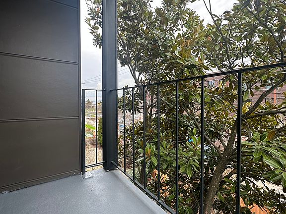 Balcony overlooking courtyard below and magnolia tree