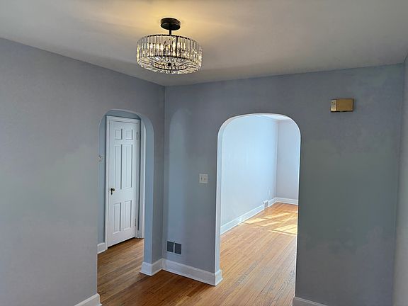 View from dining room to the living room and corridor leading into the bathroom and both bedrooms