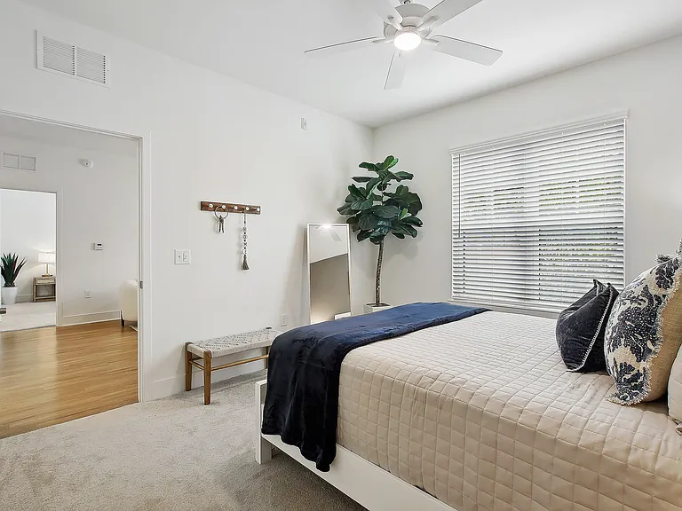Inviting bedroom with elegant decor, featuring a plush bed, cozy textiles, and abundant natural light, perfect for relaxation.