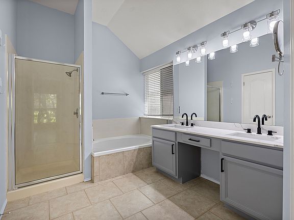 Updated Master Bathroom with double sink vanity with quartz countertops, new black faucets. Soaking tub and Shower, plus a big walk in closet