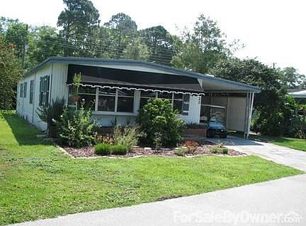 Double-wide Mobile Home
						:
						Note butterfly garden and golf car in car port
