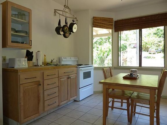 Large, bright kitchen, stove/oven, table.