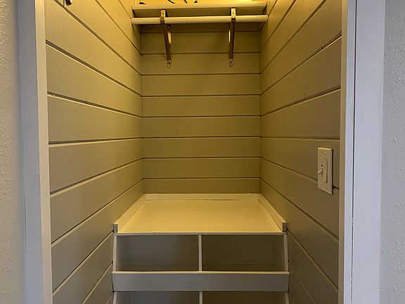 Bedroom closet/storage area with pull down ladder to attic