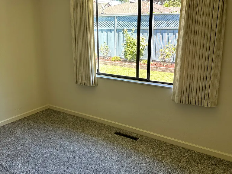 Bedroom #2 with a view of the roses in the rear yard.