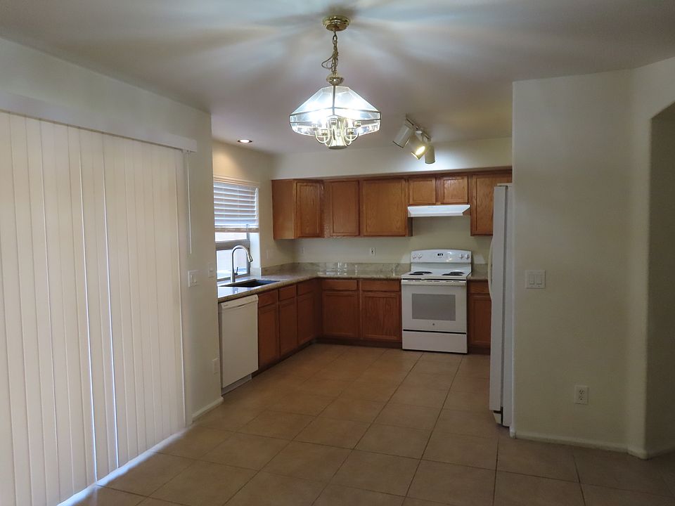 Kitchen with new granite countertops, deep black sink, and tall faucet. Tile Floor. Pull Out shelves. All appliances. Eat in Area.