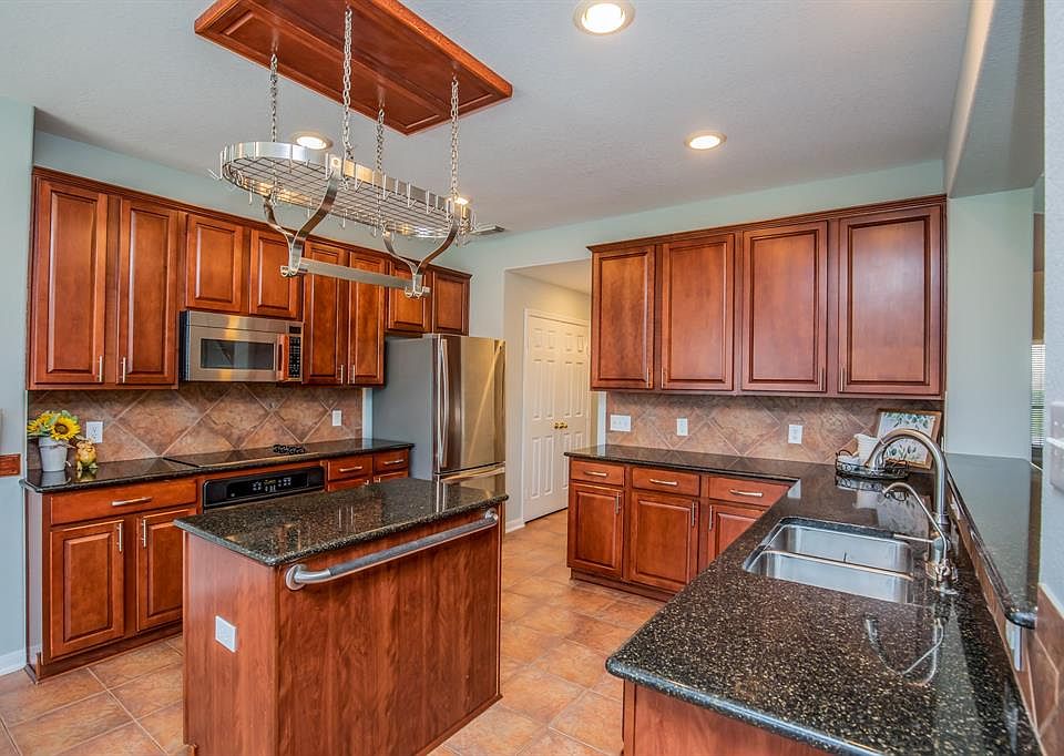 Island kitchen, 42' cabinets, new hardware and faucet, hanging pot rack, recent Bosch dishwasher, reverse osmosis under kitchen sink and FRIDGE STAYS.