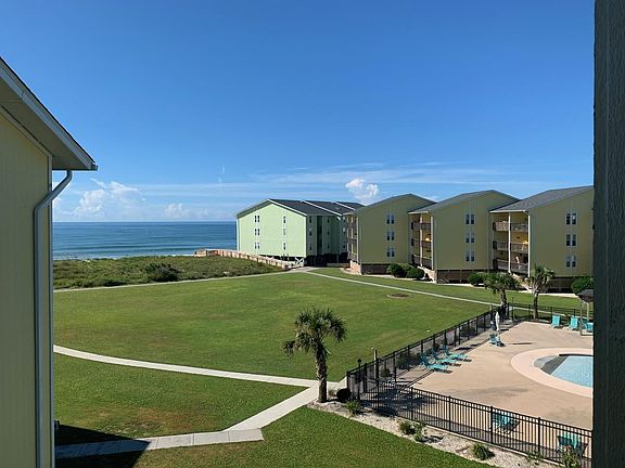 View of pool and beach from deck