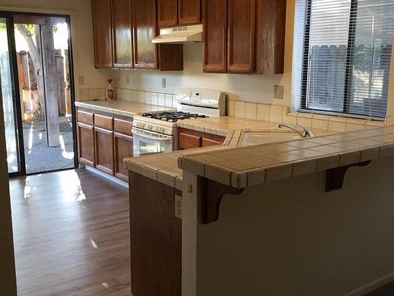 Kitchen with corner sink, breakfast bar overlooking family room